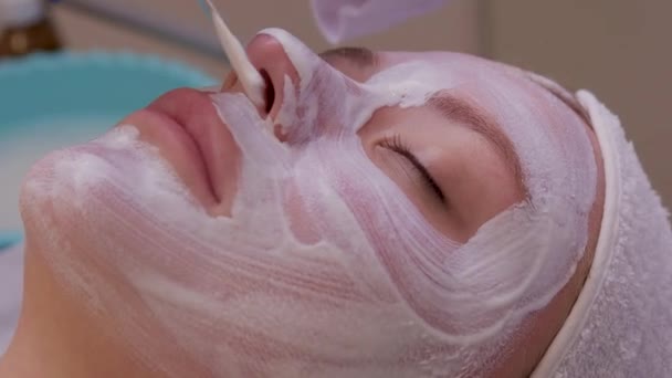 Vista dall'alto di bella giovane donna ottenere trattamento della pelle del viso. Cosmetico sta intraprendendo la procedura applicando crema. — Video Stock