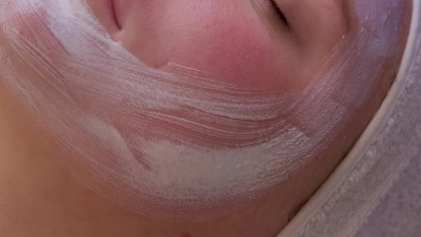 Vista dall'alto di bella giovane donna ottenere trattamento della pelle del viso. Cosmetico sta intraprendendo la procedura applicando crema. — Video Stock