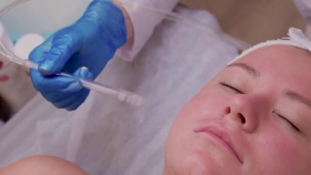 Soins de la peau. Belle femme en bonne santé obtenant sa peau analisée par le cosmétologue, utilisant l'équipement professionnel de beauté d'analyseur de peau pour l'analyse de peau de visage au centre de cosmétologie. — Video