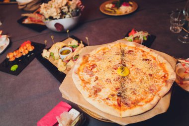 Üstünde taze fesleğen yaprakları olan ince hamurlu pizza. Bir dilim pizza. Ev yapımı yemek. İtalyan vejetaryen pizzası. Lezzetli ve sağlıklı bir yemek için konsept. Kırsal ahşap arkaplan.