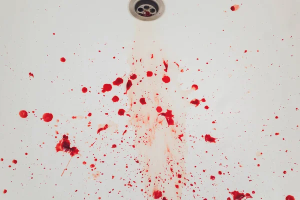 Sangre que drena del lavabo del baño blanco. Manchas sangrientas en el agujero de la cuenca. — Foto de Stock