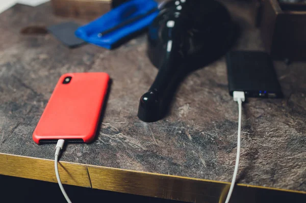 Φόρτιση Smartphone με γκρι φορητή εξωτερική μπαταρία powerbank σε ξύλινο τραπέζι . — Φωτογραφία Αρχείου