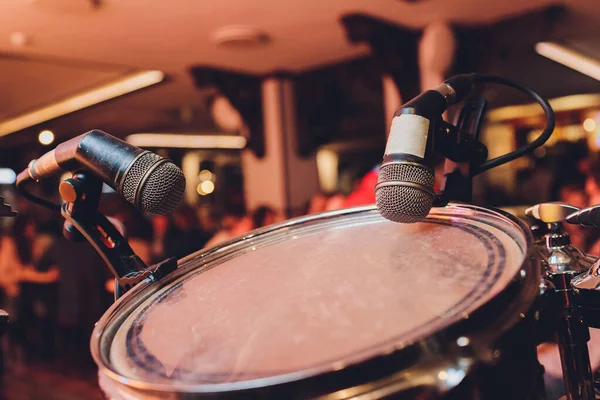A drummers view of a drum kit set up for recording in a recording studio with microphones in place.