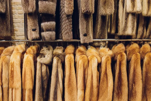 Płaszcze Mink różnych kolorów w sklepie na wieszaku. — Zdjęcie stockowe