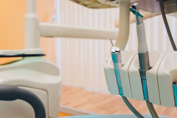 Nahaufnahme der metallischen Zahnarztwerkzeuge mit blauem Zahnarztstuhl im Hintergrund. — Stockfoto