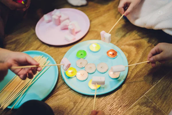 Ett barn steker marshmallows på en eld.Stekt marshmallows närbild. — Stockfoto