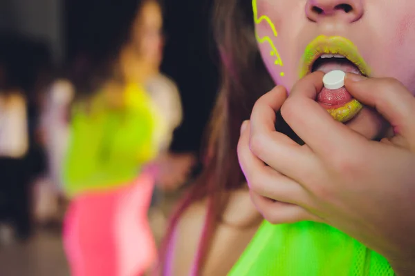 Hermosa chica con lsd en la lengua en discoteca con humo rosa. — Foto de Stock