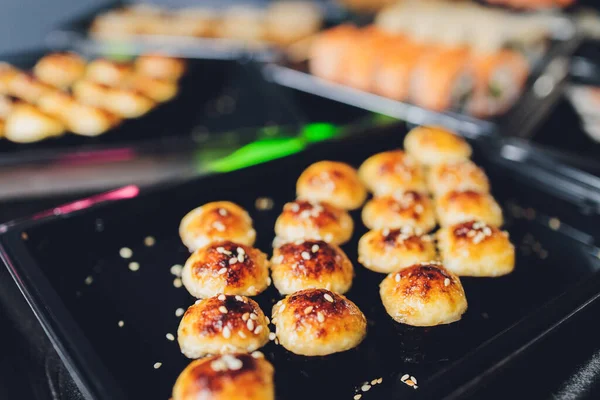 Asiatiskt matbord med olika sorters kinesisk mat, nudlar, kyckling, rullar, sushi. Serveras på gammalt träbord, asiatisk matsoppa, nudlar och sushirullar. — Stockfoto