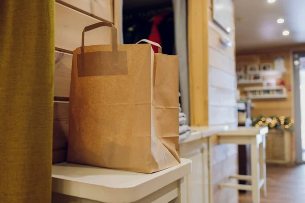 Bolsa de papel de postre esperando al cliente en el mostrador en la cafetería moderna, entrega de alimentos, restaurante cafetería, comida para llevar. — Foto de Stock