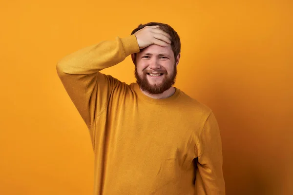 Egy egyszerű ruhás férfi képe, közelről egy boldogtalan, szakállas, kézen fogva tartó jóképű fickóról. sárga alapon elkülönítve. A szakállas férfi. — Stock Fotó