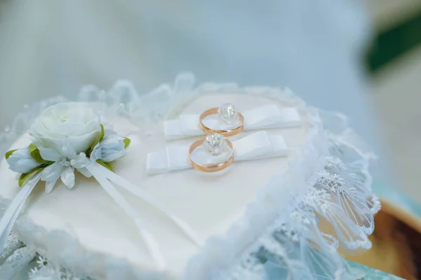 Golden wedding rings on decorated little pillow. — Stock Photo, Image
