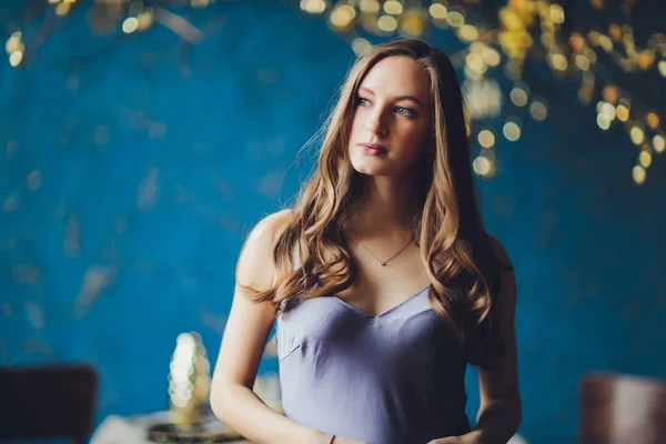 Joven mujer embarazada hermosa con cabello rubio y maquillaje suave en vestido de moda posando cerca en el estudio. — Foto de Stock