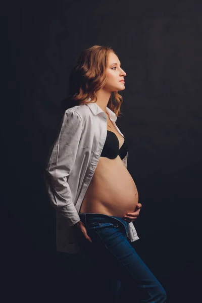 Młoda piękna stylowa kobieta w ciąży pozowanie w czarnej bieliźnie. — Zdjęcie stockowe