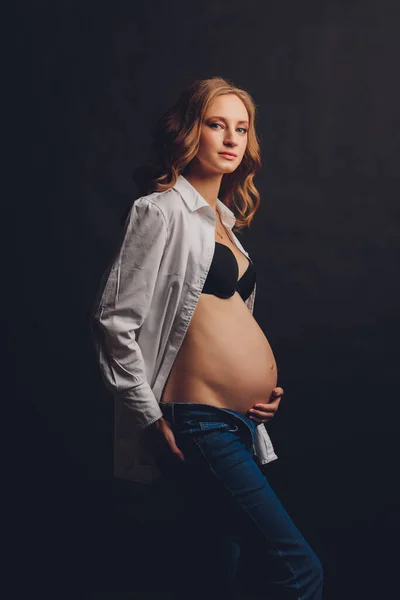 Ung vacker snygg gravid kvinna poserar i svarta underkläder. — Stockfoto