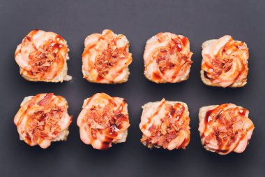 Siyah arka planda somon balıklı Maki Suşi Rolls. Zencefil ve wasabi ile. Suşi menüsü. Japon yemeği. Sushi dürümlü lezzetli Japon yemeklerini yakından çek. Yatay fotoğraf.