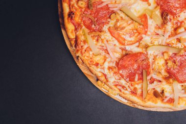 Pizza pepperonisi, mozzarella, siyah arka planda kekik otu..