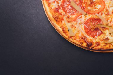 Pizza pepperonisi, mozzarella, siyah arka planda kekik otu..