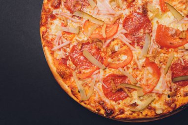 Pizza pepperonisi, mozzarella, siyah arka planda kekik otu..