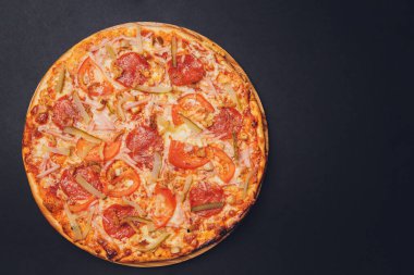 Pizza pepperonisi, mozzarella, siyah arka planda kekik otu..