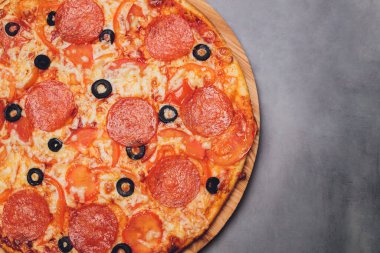 Pizza pepperonisi, mozzarella, siyah arka planda kekik otu..