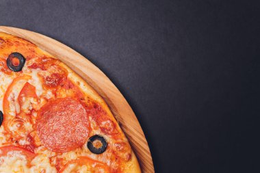 Pizza pepperonisi, mozzarella, siyah arka planda kekik otu..