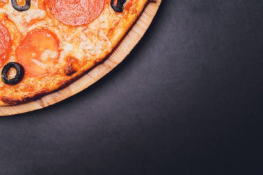 Pizza pepperonisi, mozzarella, siyah arka planda kekik otu..