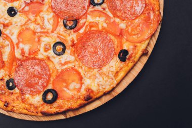 Pizza pepperonisi, mozzarella, siyah arka planda kekik otu..