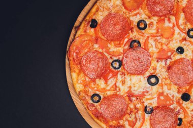 Pizza pepperonisi, mozzarella, siyah arka planda kekik otu..