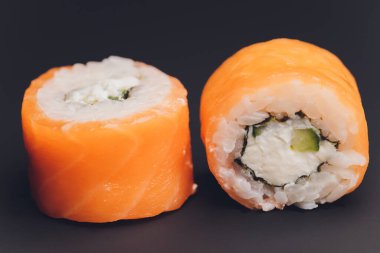 Siyah arka planda servis edilen çeşitli suşi yemekleri..