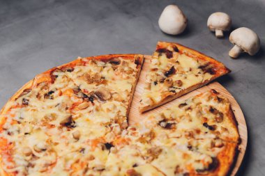 Kaba ahşap tepside ve arka planda pizza dilimleri.