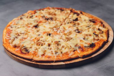 Kaba ahşap tepside ve arka planda pizza dilimleri.