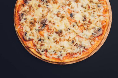 Kaba ahşap tepside ve arka planda pizza dilimleri.