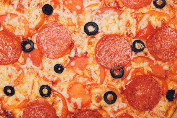 Pizza peperoni, mozzarella, origano su fondo nero. — Foto Stock