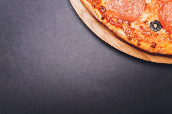 Pizza pepperonisi, mozzarella, siyah arka planda kekik otu..