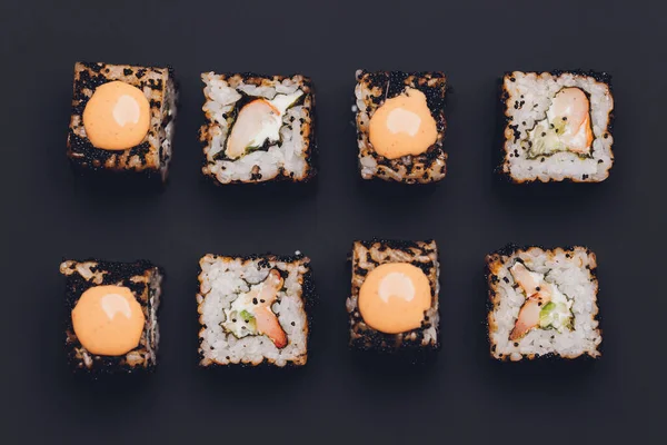 Rollos de sushi Maki con salmón sobre piedra negra sobre fondo oscuro. Con jengibre y wasabi. Menú de sushi. Comida japonesa. Primer plano de deliciosa comida japonesa con rollo de sushi. Fotografía horizontal. — Foto de Stock
