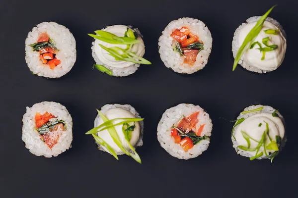 Maki Sushi Rolls lazaccal fekete kövön, sötét háttérrel. Gyömbérrel és wasabival. Sushi menü. Japán kaja. Szekrény finom japán ételeket sushi roll. Vízszintes fénykép. — Stock Fotó