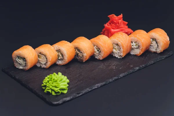 Различные виды суши питание подается на черном фоне. — стоковое фото