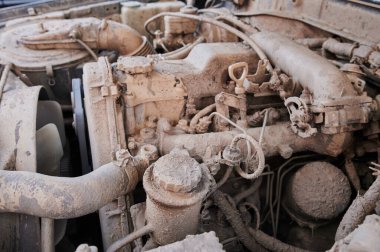 Açık kaputun altındaki dört silindirli boxer motor bölümünün tozlu detayları. Alternatör ve emme manifoldu. Güneşli bir günde yakın görüş.