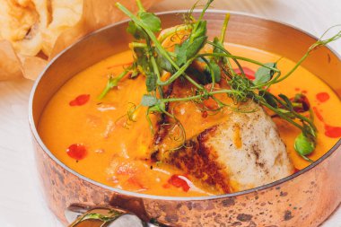 Rezene tohumları ve baharatlı hardal sosuyla süslenmiş, kızarmış vişneli domates salatası ve mor fesleğenle servis edilen kızarmış halibut..