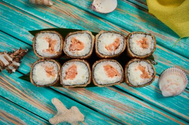 Suşi seti ve ahşap tahtada suşi rulosu..