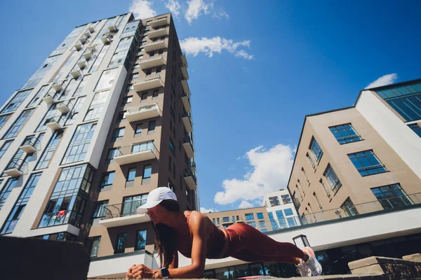 Junge Frau macht Liegestütze auf der Treppe auf der Straße, urbanes Sportkonzept. — Stockfoto