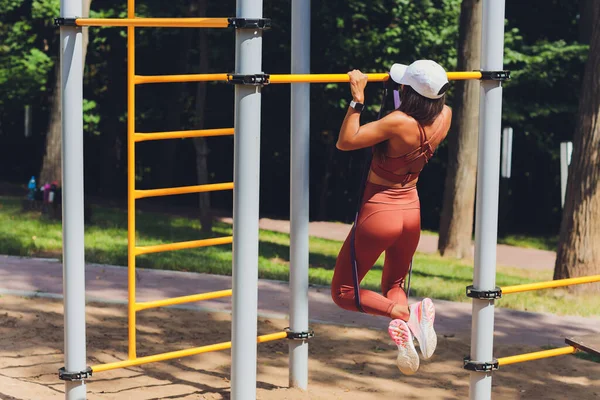 열정적 이고 집중력있는 운동 여성이 스포츠를 하고, 운동을 하고, 고무줄로 운동을 하고, 근육을 펴고, 근력 운동을 하기 위해 고무줄을 사용 한다. — 스톡 사진
