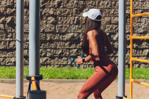 一个有弹性带的年轻女运动员在城市的室外做运动. — 图库照片