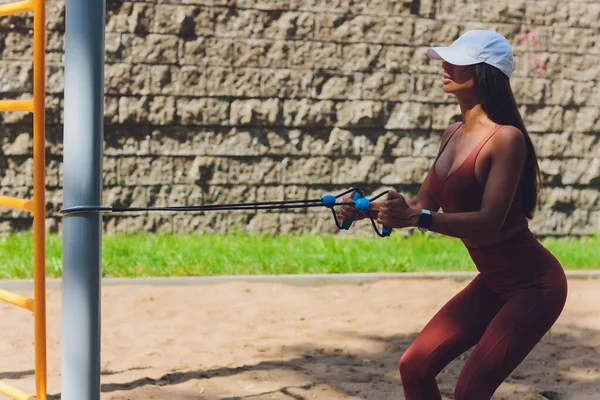 En ung idrottskvinna med elastiskt band som tränar utomhus i stan. — Stockfoto