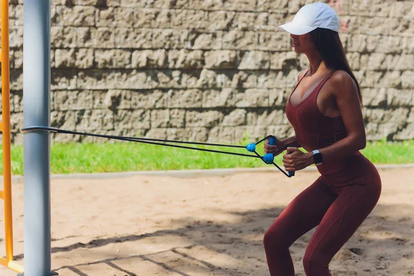 Una giovane sportiva con elastico che fa esercizio all'aperto in città. — Foto Stock