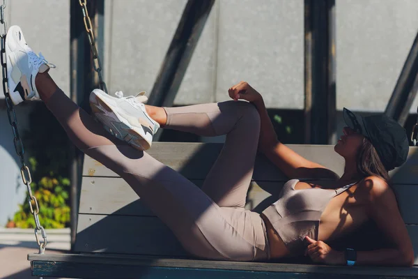 Spor kadını bankta dinlenirken müzik dinliyor.. — Stok fotoğraf