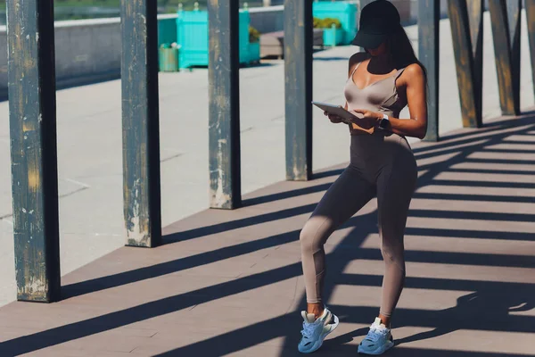 Primo piano ritratto di felice giovane donna d'affari bionda utilizzando tablet pc nel parco. Vista frontale di una ragazza sorridente che tiene un tablet digitale all'aperto. Luce del sole di bagliore. — Foto Stock