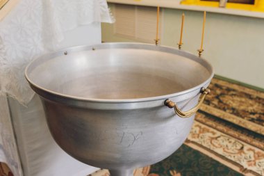 Bebeği kilisede yıkamak için yazı tipine su dökülüyor, dini gelenekler..