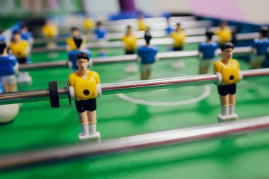 Başlangıç maçında topa odaklan. Erkek oyuncağı spor oyunu konsepti. Futbol masası, çocuk ve aile için evde rahatlama aktivitesidir..