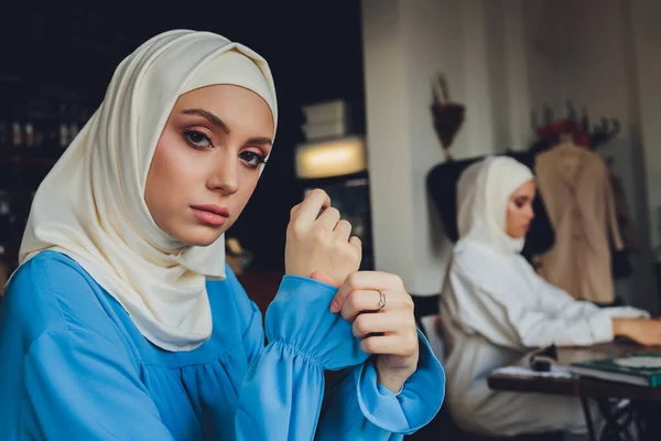 Retrato de una hermosa mujer musulmana asiática modelo con blusa blanca y hiyab azul posando sobre una cortina blanca como fondo en vista de cerca. —  Fotos de Stock